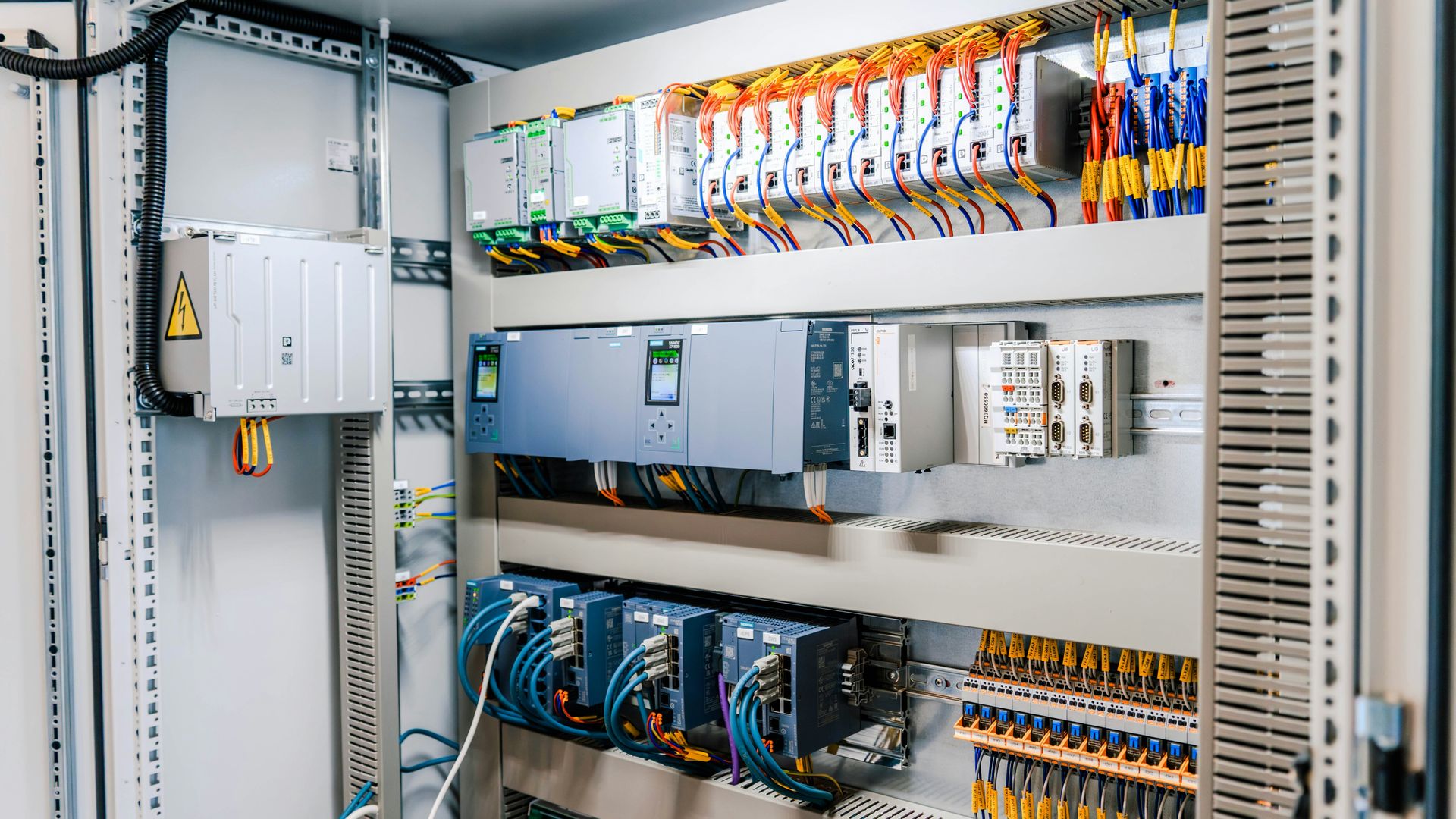Open electrical control cabinet showing terminal blocks and DIN-rail wiring