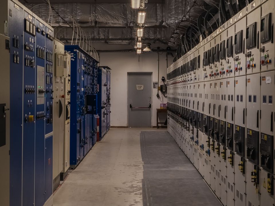 Wide aisle of electrical switchgear and distribution panels in an industrial control room