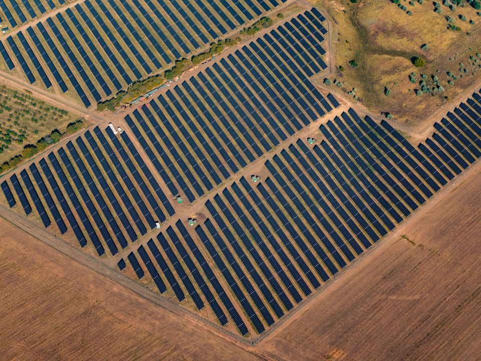 Aerial view of solar panel rows across a large-scale solar farm, showing row spacing and layout